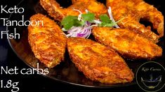 some fried food is on a black plate and has a green leafy garnish