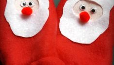 two red santa claus slippers with googly eyes and nose are shown in front of the camera