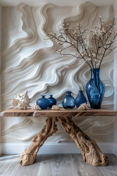 a table with vases and shells on it in front of a wallpapered background