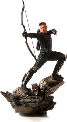 the action figure is posed on top of a rock with a bow and arrow in his hand