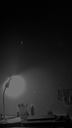 a black and white photo of a desk with a lamp