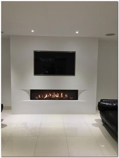 a living room with two black couches and a flat screen tv on the wall