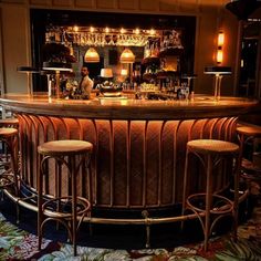 a bar with three stools in front of it