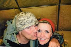 a man and woman taking a selfie in front of a tent