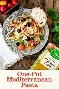 one pot mediterranean pasta with fresh basil, tomatoes and olives on a wooden table