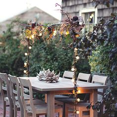 an outdoor table and chairs with lights on them