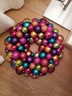 a wreath made out of christmas ornaments on the floor