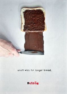 a piece of bread with chocolate spread on it being held by a person's hand