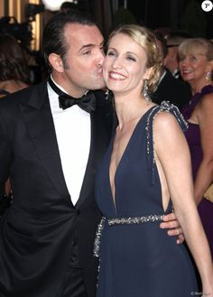 a man in a tuxedo kissing a woman on the cheek at an event