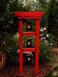 a tall red shelf sitting in the middle of a garden