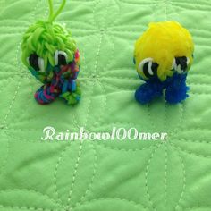 two small plastic toys sitting on top of a green quilt