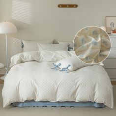 a bed with blue and white comforters in a bedroom next to a night stand