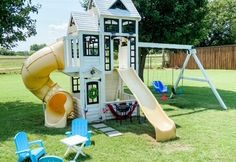 a play house with a slide and chairs in the yard