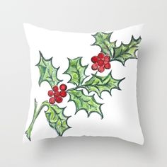 a white pillow with holly and berries on it