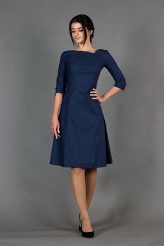 A cocktail dress in minimalist style featuring fit and flare silhouette, midi length, and 3/4 sleeves. - asymmetrical v-neck - 3/4 sleeves - flared skirt with inverted front pleat - fit and flare silhouette  - midi length  - extraordinary dart in the front - concealed back zipper closure Color: dark blue Fabric: cotton - 95%, elastane - 5%  For Size 2 US / 36 EU: dress length - 40" (101 cm), sleeve length - 15,3" (39 cm) Our model wears size 2 US. Model in the photo: 64,5" (164 cm)  height 33" ( Dark Blue Dress Formal Long Sleeve, Simple Cocktail Dress, Skater Dresses Casual, Cocktail Dress Holiday, Fall Wedding Guest Dress, Women Business, Business Dress, Blue Cocktail Dress, Professional Dresses