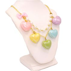 A cute and sweet statement necklace for Valentine's Day or lovecore season! This kawaii charm necklace includes Five heart shaped macaron ( macaroon ) pendants in pastel shades with a pearly finish and whipped cream center. Each necklace includes five 1" (2.5 cm) size charms hanging on a two-layered chain necklace with glass pearls on your choice of a 21" gold plated or silver plated chain. Accented with a baby pink fabric ribbon bow on one side. Necklace will be finished with a Fatally Feminine Kawaii Necklaces For Valentine's Day, Cute White Necklace With Heart Charm, Cute Pastel Jewelry For Gifts, Cute Pastel Jewelry For Gift, Sweet Heart-shaped Necklace For Valentine's Day, Cute Multicolor Charm Necklaces For Valentine's Day, Cute Multicolor Charm Necklace For Valentine's Day, Cute Multicolor Heart Necklace For Gift, Multicolor Heart-shaped Kawaii Jewelry