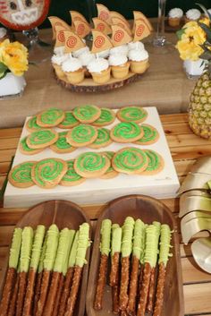 an assortment of cookies and desserts displayed on wooden trays in front of a table