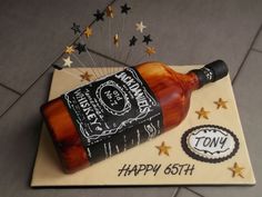 a birthday cake made to look like a bottle of whiskey on top of a table