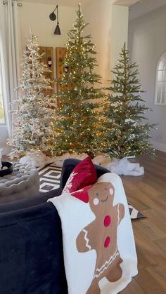 the living room is decorated with christmas trees and holiday decorations, including a teddy bear blanket