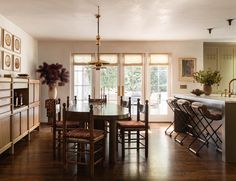 a dining room table and chairs in front of an open kitchen area with sliding glass doors