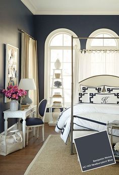 a bedroom with blue walls and white furniture