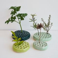 three planters sitting on top of each other with plants growing out of the holes in them