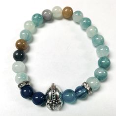 The Beads In This Bracelet Are Different Shades Of Blue Beads Either So. It Has Four Blue Beads Two On Either Side Of The Silver Roman Helmet. Has Two Silver Spacers With Clear Crystals. Will Comfortably Fit An 8 Inch Wrist Blue Crystal Bracelet With Colorful Beads, Blue Crystal Bracelet With Spacer Beads, Adjustable Blue Stretch Bracelet With Gemstone Beads, Adjustable Blue Beaded Bracelets With Gemstones, Adjustable Blue Gemstone Beads Stretch Bracelet, Adjustable Blue Gemstone Beaded Bracelets, Blue Gemstone Beads Stretch Bracelet, Adjustable Blue Gemstone Beaded Bracelet, Blue Stretch Bracelet With 8mm Beads For Jewelry Making