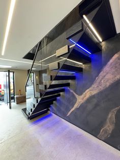 a modern staircase with blue lights in the middle and black steps leading up to it