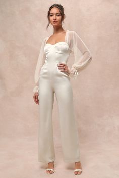 You'll stun at every event you RSVP to in the Lulus Gracefully Modern Ivory Satin Mesh Long Sleeve Bustier Jumpsuit! Airy mesh fabric (with a Swiss dot-inspired design) shapes long balloon sleeves that have ruffled elastic cuffs with decorative bows, along with matching ruffles and elastic at the shoulders. Sleek woven satin shapes a bustier-style bodice with hidden no-slip strips, seamed cups, and a sweetheart neckline. Fitted waist tops chic, straight legs that fall to ankle-length hems. Hidde Bustier Jumpsuit, Jumpsuit Satin, Engagement Party Outfit, Bride Jumpsuit, Garden Party Bridal Shower, Ruffled Tops, Fem Fashion, Lulu Pants, Bachelorette Party Dress