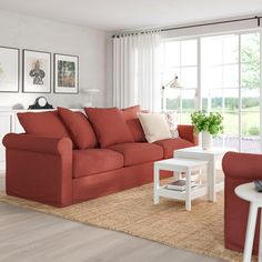 a living room with red couches and pictures on the wall above them, along with a white coffee table