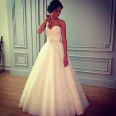 a woman in a white wedding dress is posing for the camera with her hand on her head