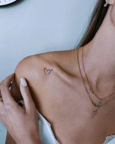 a woman with a heart tattoo on her chest