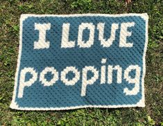 a crocheted afghan with the words i love pooping written in white on it