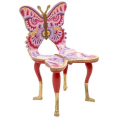 a pink and purple butterfly chair sitting on top of a wooden table