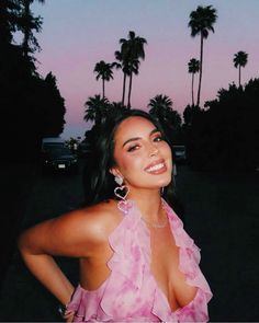 a woman in a pink dress posing for the camera