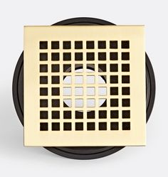 an image of a square shower grate with squares on the surface in gold and black