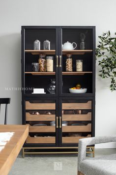 a black and wood cabinet with glass doors in a dining room next to a table