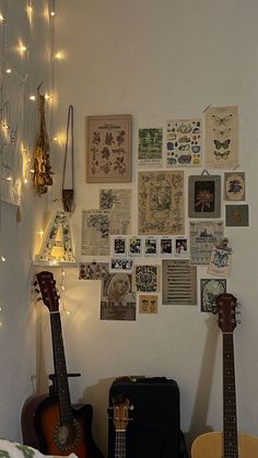 two guitars are sitting in front of a wall with many pictures on it