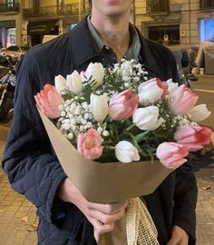 a man holding a bouquet of flowers in his hands