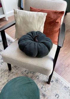 a chair with pillows on it and a rug in front of the chair is shown