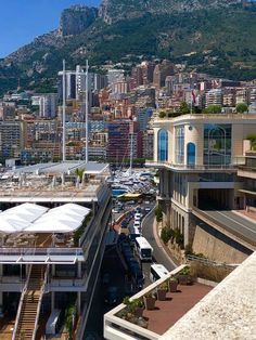 an aerial view of a city with mountains in the back ground and buildings on either side