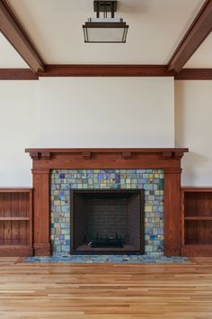 an empty living room with a fireplace and bookcases