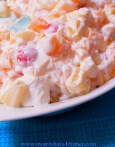 a white plate topped with fruit salad on top of a blue table