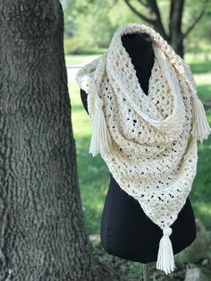 a white crocheted scarf hanging from a tree