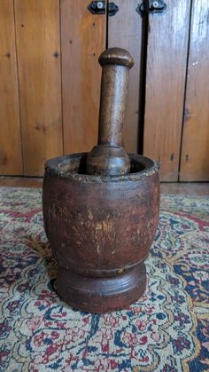 an old wooden mortar and pestle on a rug