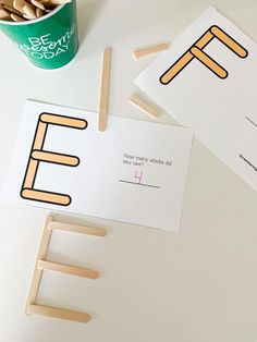 two cards with the letters e and f on them, next to a cup of coffee