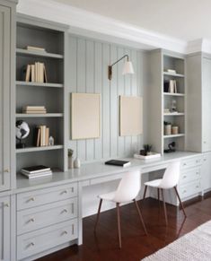 a white desk sitting in the middle of a room with bookshelves and chairs