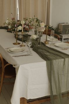 the table is set with white plates and silverware