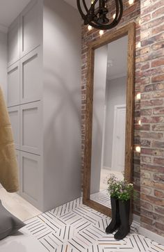 a bathroom with a brick wall and white flooring, a large mirror on the wall