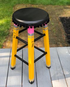 a black and yellow stool sitting on top of a wooden floor